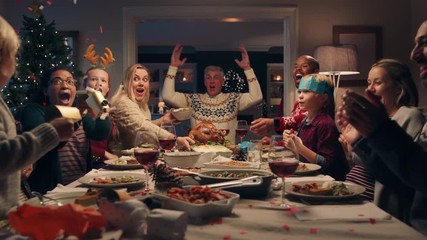 happy family christmas dinner party celebrating with crackers sharing homemade feast with friends enjoying evening of fun holiday celebration at home 4k footage - Powered by Adobe