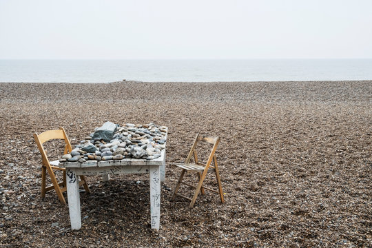 Pebble on old wooden table with chairs
