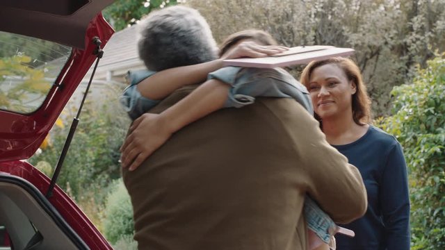 young girl moving out of house leaving for college packing luggage in car hugging parents goodbye mother and father embracing daughter farewell 4k footage