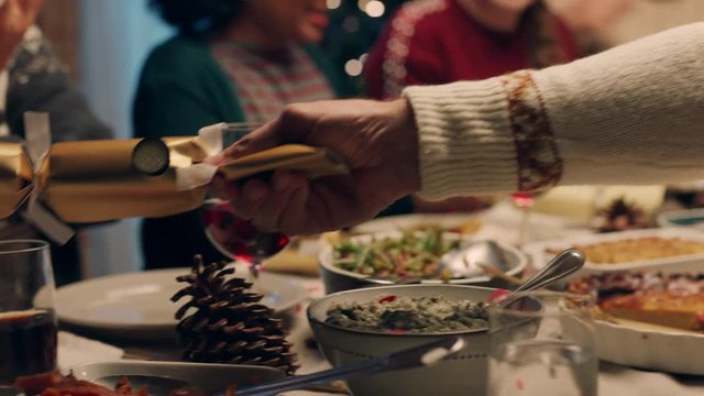 happy family christmas dinner party celebrating with crackers sharing homemade feast with friends enjoying evening of fun holiday celebration at home 4k footage
