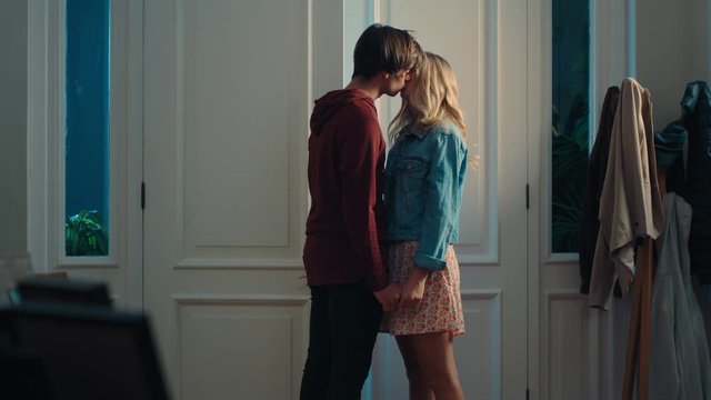 happy teenage couple first kiss girl kissing boyfriend at home after romantic evening date together 4k