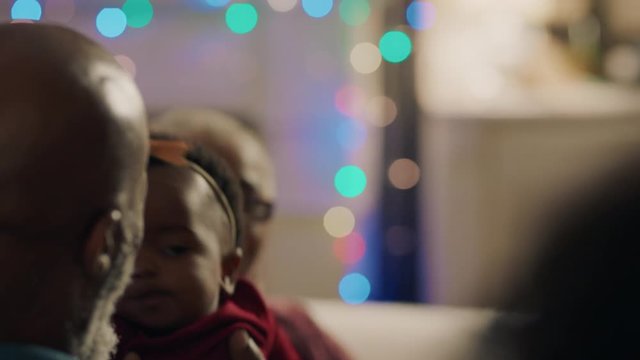 african american family christmas grandfather holding baby girl giving kiss proud of granddaughter happy grandparents enjoying festive holiday reunion at home 4k