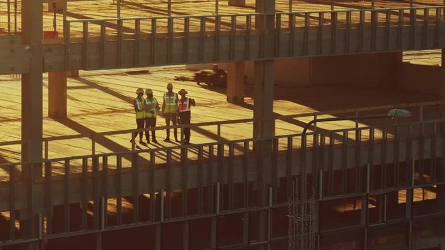 Aerial View: Diverse Team of Specialists Inspect Commercial, Industrial Building / Skyscraper Formwork Construction Site