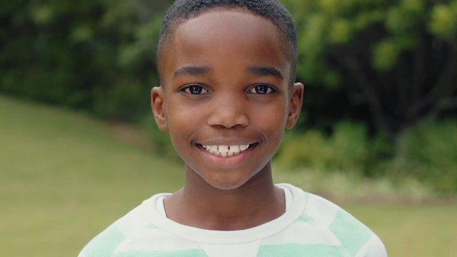 portrait cute african american boy smiling with playful excitement looking happy having fun in sunny park outdoors enjoying childhood testimonial concept 4k footage