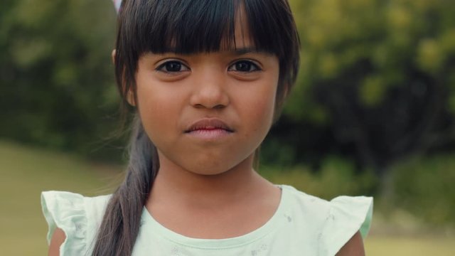 portrait beautiful little hispanic girl looking happy cute child having fun in sunny park outdoors enjoying childhood testimonial concept 4k footage