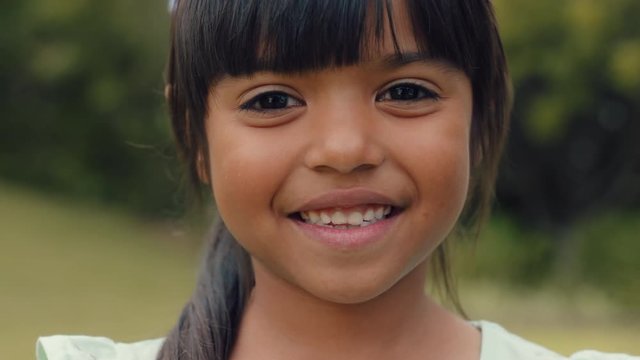 portrait beautiful little girl smiling looking happy cute child having fun in sunny park outdoors enjoying childhood testimonial concept 4k footage