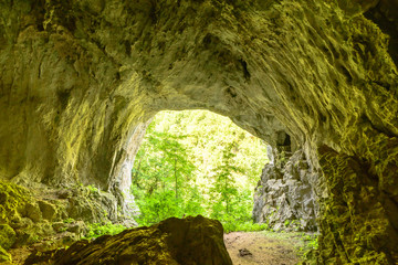 From the inside of a cave, the exit is visible.