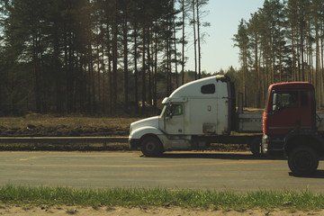 Big truck on the roadside near forest. white lorry on a road