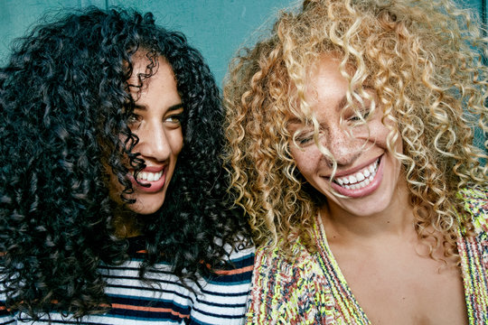 Close up of smiling young women in curly hair