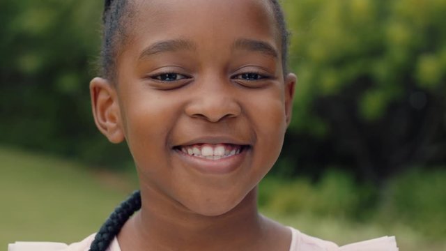 portrait cute african american girl smiling with playful excitement looking happy having fun in sunny park outdoors enjoying childhood testimonial concept 4k footage
