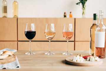 wine glasses, bottles and food on wooden table