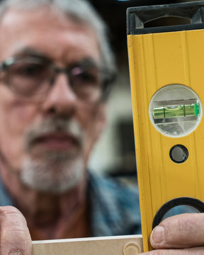 Close up of carpenter measuring wood with spirit level