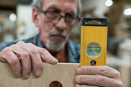 Close up of carpenter measuring wood with spirit level