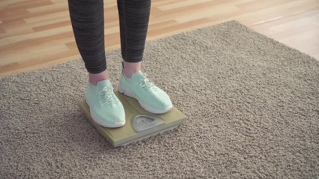Weight control concept,women's feet on the floor scales in the living room