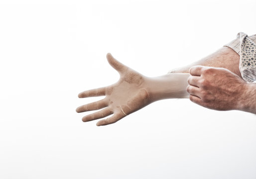 Close Up Of Man's Hand Pulling On Medical Glove