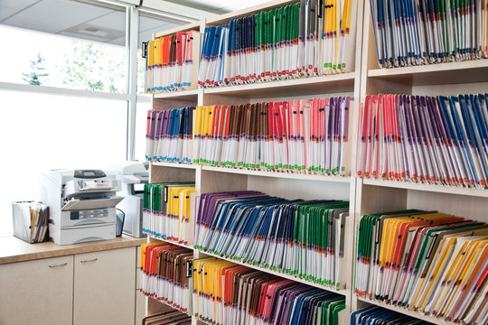 View of colorful file folders arranged on shelf in dental office
