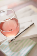 Glass of wine on a marble table with a sketch pad and pencil
