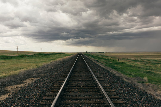 Storm clouds over rail track passing through prairie