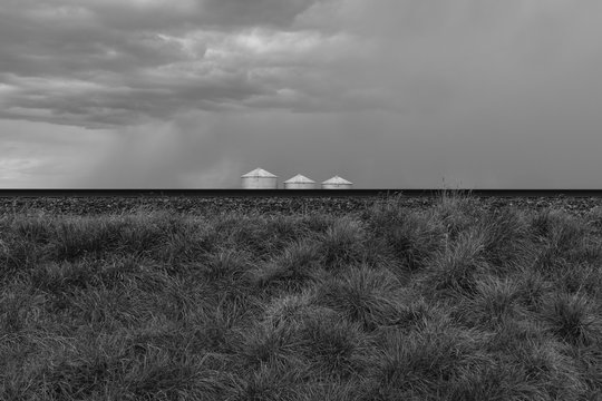 Stormy clouds over grain silos on farmland