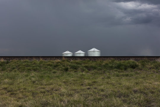 Stormy clouds over grain silos on farmland