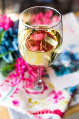 Glass of white wine at a table with art and flowers