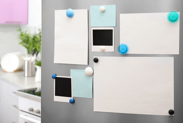 Sheets of paper and photos with magnets on refrigerator door indoors. Space for text