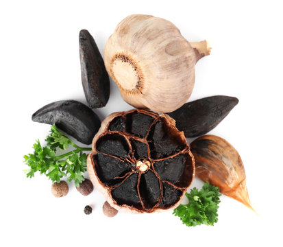 Aged black garlic with parsley on white background, view from above