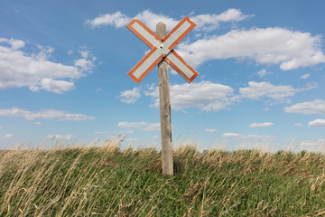 Railroad caution sign on prairie landscape