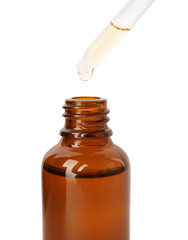 Brown bottle and dropper with essential oil on white background