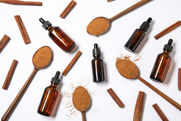 Flat lay composition with cinnamon essential oil on white background