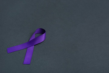 Purple awareness ribbon on black background, space for text