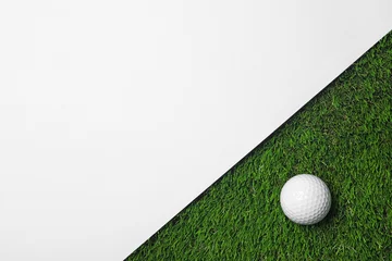 Poster Golf ball and white paper on green artificial grass, top view with space for text © New Africa