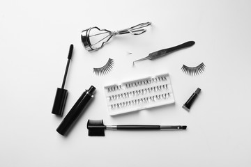 Naklejka premium Composition with false eyelashes and tools on white background, top view
