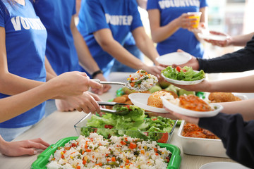 Volunteers serving food to poor people, closeup