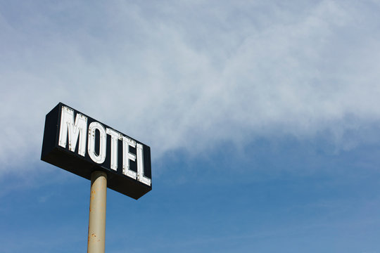 Motel sign against cloudy sky