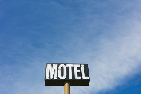 Motel sign against cloudy sky