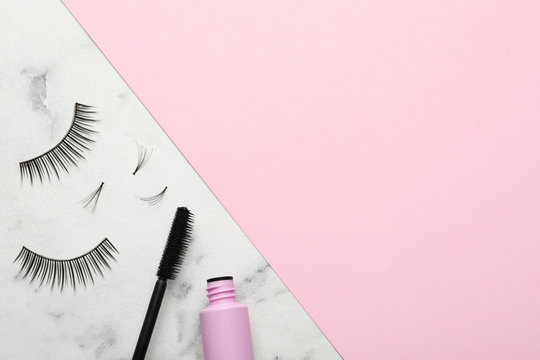 False eyelashes and mascara on color background, flat lay. Space for text