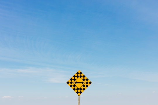 View of arrow intersection sign against cloudy sky