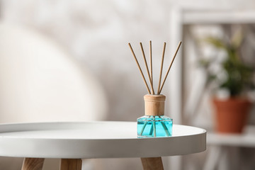 Fototapeta premium Reed air freshener on white table indoors, space for text