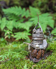 Fairy houses built in the dense forest out of sticks, bark, pinecones and moss. 