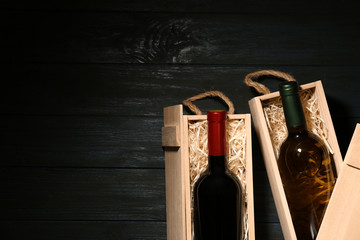Crates with bottles of wine on wooden table, flat lay. Space for text