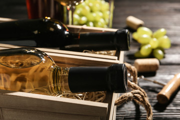 Wooden crates with bottles of wine on table, closeup