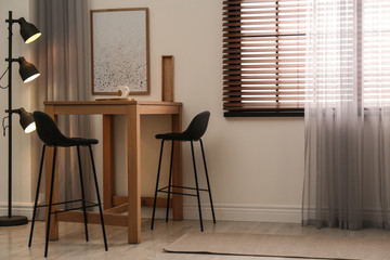 Modern room interior with table set, window blinds and stylish decor elements