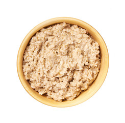 Wooden  bowl with prepared oatmeal  isolated on white background. Top view.