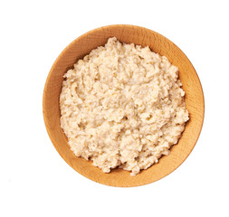 Wooden  bowl with prepared oatmeal  isolated on white background. Top view.