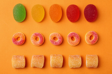 Flat lay composition with delicious jelly candies on color background