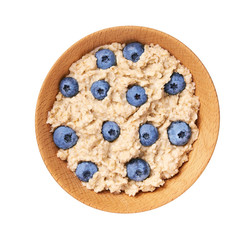 Oatmeal porridge  with blueberry  in wooden bowl isolated. Delicious and healthy food for breakfast. Top view.