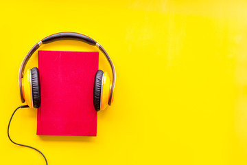 listen to audio books with headphone on yellow background flatlay mock up