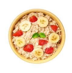 Wooden bowl of oatmeal porridge with banana and strawberry  isolated. Delicious and healthy food for breakfast. Top view.