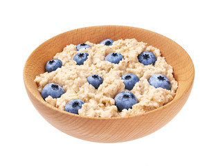 Oatmeal porridge  with blueberry  in wooden bowl isolated. Delicious and healthy food for breakfast.